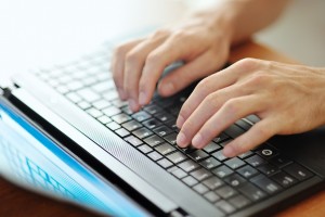 male hands typing on a laptop pc keyboard